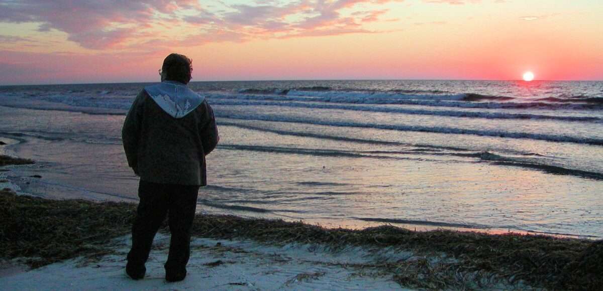 man alone on beach at sunset