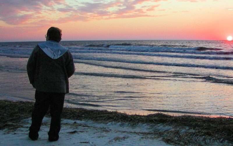 man alone on beach at sunset